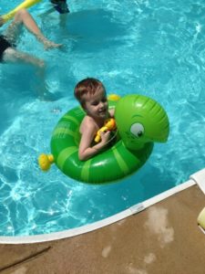 boy floating with inner tube in pool