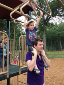 dad helping boy on monkey bars