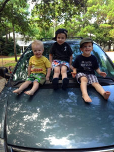 3 boys sitting on van