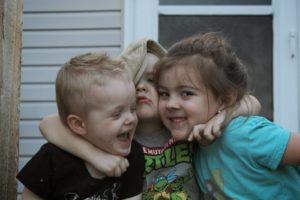 young boy hugging friends