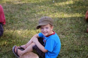 little boy sitting on grass