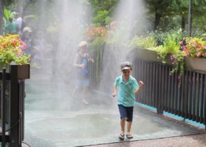 boys running through sprinkler