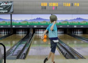 young boy bowling